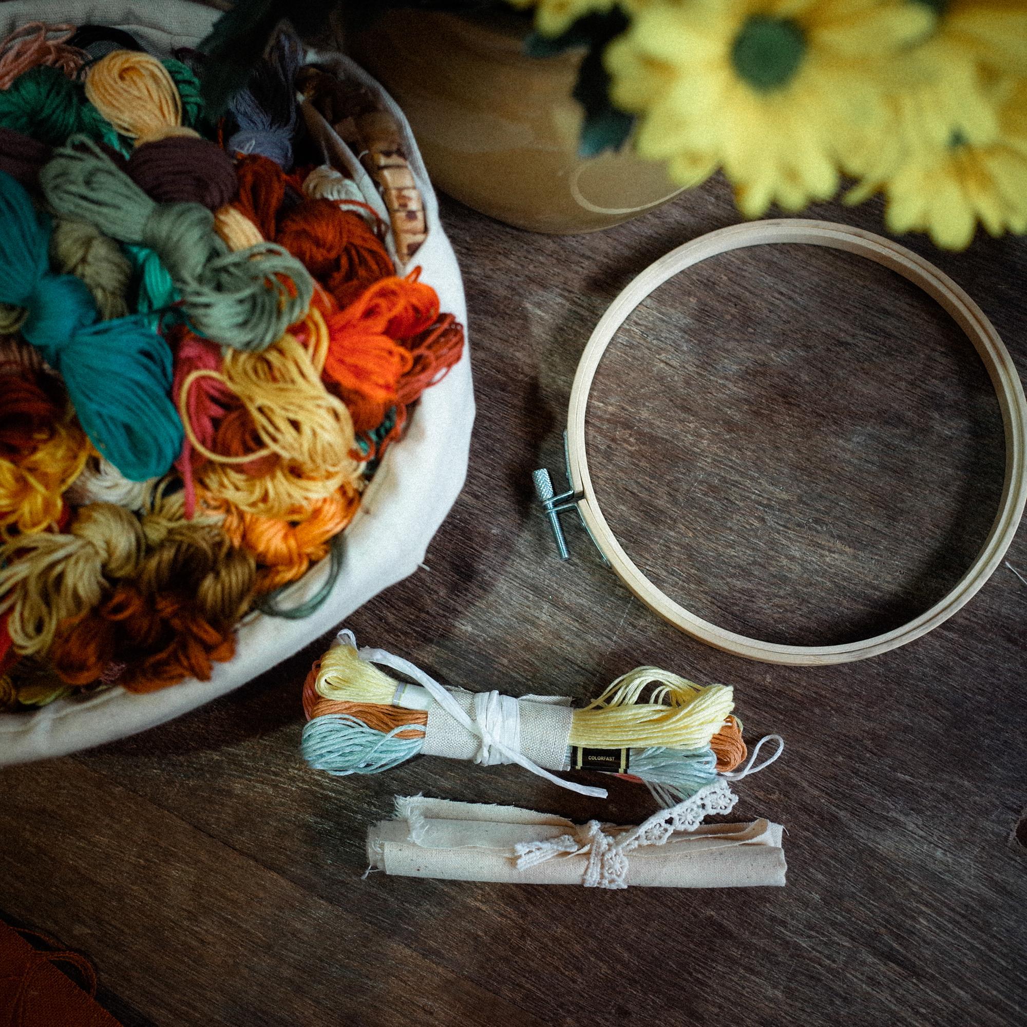 Studio workspace with hoops, threads and finished embroidery